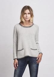 Bernadette knitted sweater with pockets and contrast color edges, knitted in grey Önling yarn.